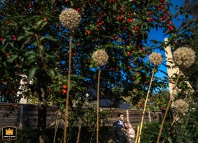 In London, England, the wedding couple poses for a romantic portrait set within the lush, beautifully manicured gardens of their ceremony location.